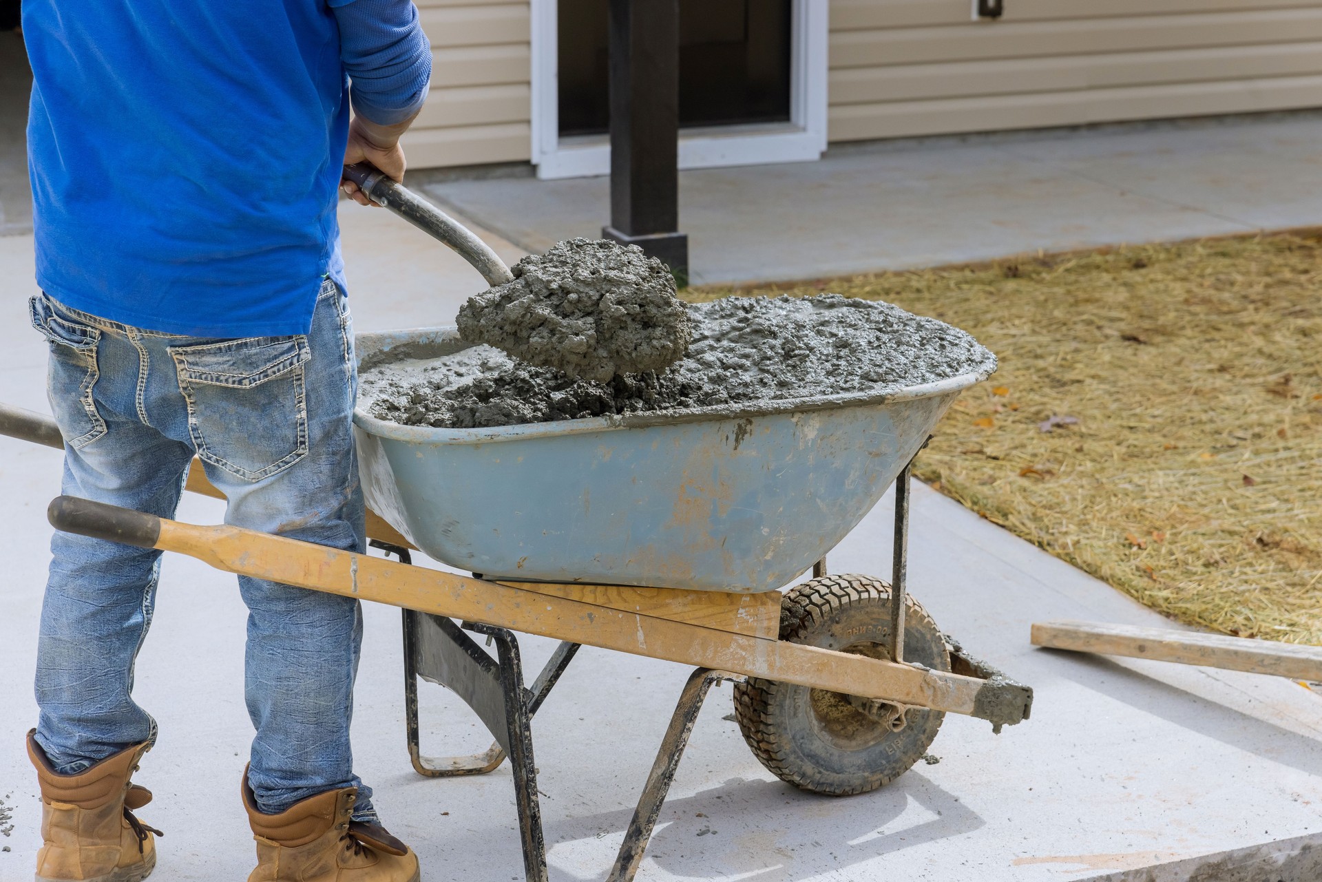 Construction contractors pouring wet concrete while paving a driveway as they work on a concrete construction project